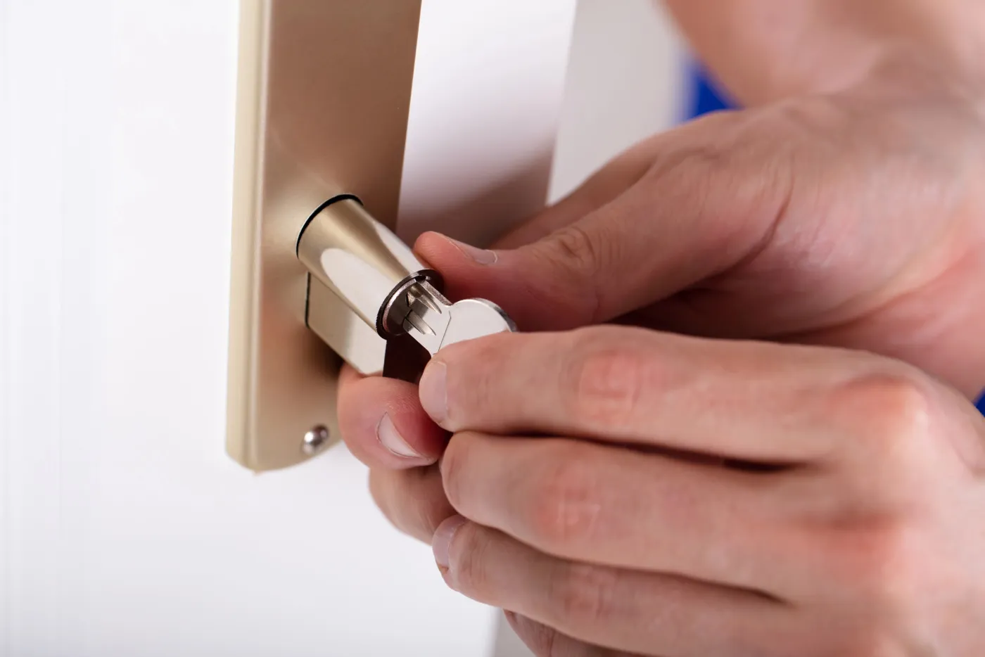 Artisan serrurier du réseau ajustant un cylindre sur une porte d'appartement parisien